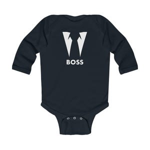 Puede incluir: Un body de beb&eacute; de manga larga azul oscuro con un gr&aacute;fico blanco de un cuello de esmoquin y la palabra "BOSS" debajo.