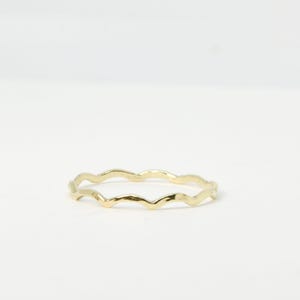 Peut inclure: Une fine bague en or avec une bande ondulée et texturée.
