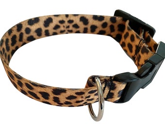 May include: A brown and black leopard print dog collar with a black plastic buckle and a silver metal D-ring.