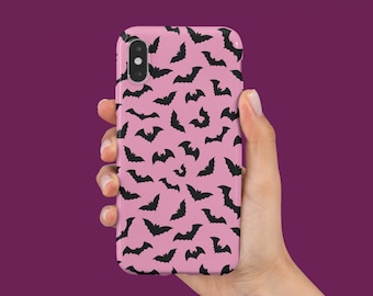 May include: A pink phone case with a black bat pattern.