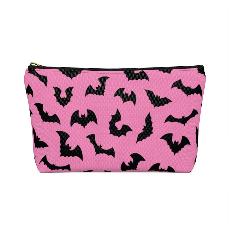 May include: Pink zippered pouch with a black bat pattern.