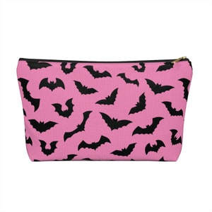 May include: Pink zippered pouch with a black bat pattern.