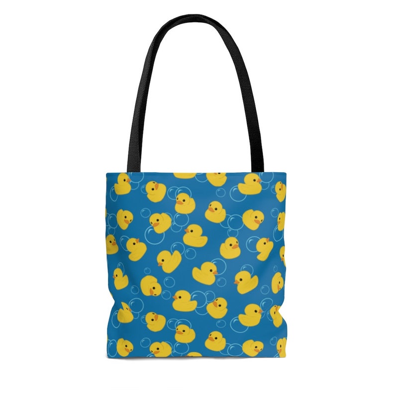 May include: A blue tote bag with a pattern of yellow rubber duckies and white bubbles.