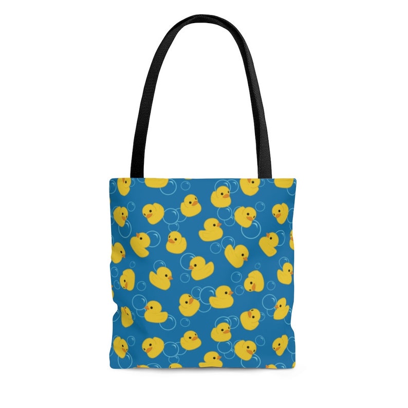 May include: A blue tote bag with a pattern of yellow rubber duckies in bubbles.