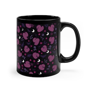 May include: Black coffee mug with a pattern of purple rubber ducks, bats, hearts, stars, and skulls on a black background.
