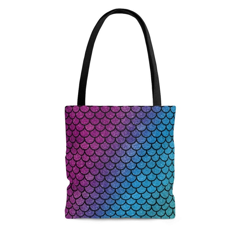 May include: A tote bag with black handles and a mermaid scale pattern in shades of pink, purple, blue, and teal.