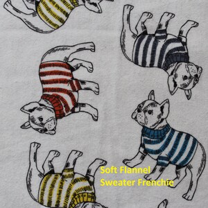 May include: White flannel fabric featuring a repeating pattern of French Bulldogs wearing striped sweaters in various colors. The text "Soft Flannel Sweater Frenchie" is visible in yellow.