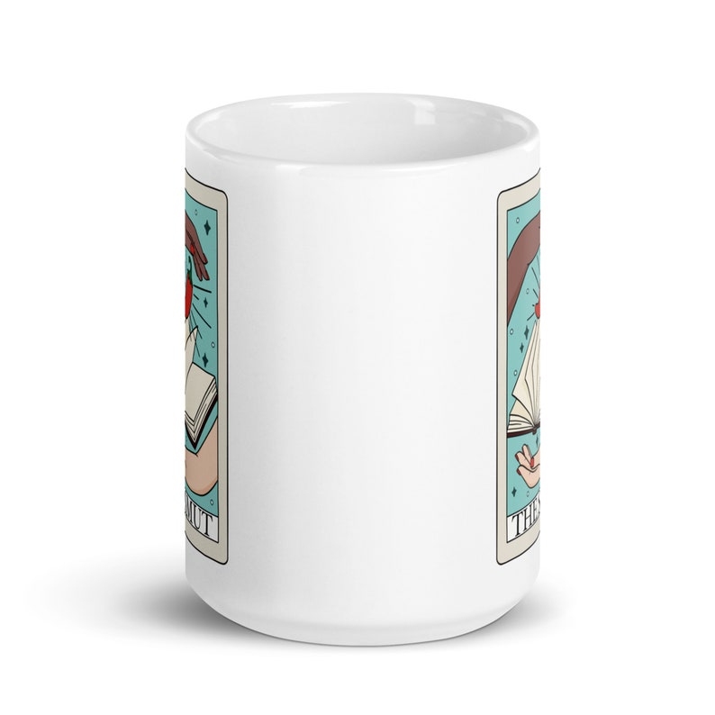 The smut tarot card mug, two hands with book and chilli pepper on tarot card with text that says the smut. Keywords: bookish mug, bookworm mug, fantasy romance, dark romance, spicy books, smut reader, monster romance, bookish merch