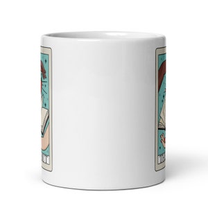 The smut tarot card mug, two hands with book and chilli pepper on tarot card with text that says the smut. Keywords: bookish mug, bookworm mug, fantasy romance, dark romance, spicy books, smut reader, monster romance, bookish merch