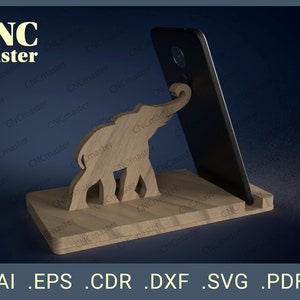 May include: A wooden phone stand with an elephant design. The stand is made of light brown wood and has a cutout of an elephant with its trunk raised. The stand is designed to hold a smartphone in a vertical position.