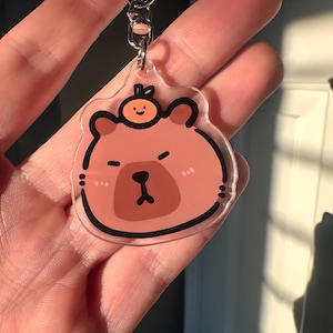Carpincho con una naranja en la cabeza: llavero acrílico con forma de animal kawaii, regalo divertido para amantes de los animales