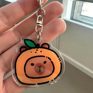 Lindo llavero acrílico con forma de capibara y naranja: adorable amuleto de animal, regalo kawaii, accesorio para amantes de las capibaras