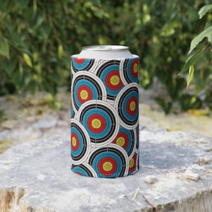 Może przedstawiać: Cylindryczny chłodziarka do puszek z powtarzającym się wzorem tarcz łuczniczych w kolorze czerwonym, żółtym, niebieskim i czarnym na białym tle. Chłodziarka jest przeznaczona do standardowej puszki po napoju. Tło to naturalne otoczenie zewnętrzne.