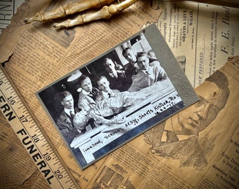 May include: A black and white photograph of a group of men standing around a table with a body lying on it. The photo is dated 10.22-17. The caption reads "Townsend, Scruggs, Hess, Sheets Kistler, Ros 10.22-17."