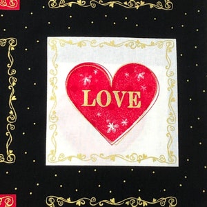 May include: A red heart with the word "LOVE" in gold lettering on a white background with a gold ornate frame. The background is black with gold polka dots.