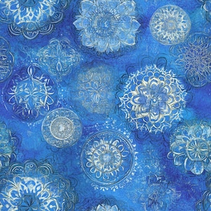 May include: A blue fabric with a repeating pattern of stylized, circular floral designs in shades of blue and white. The design has a watercolor effect, with a textured, mottled background.