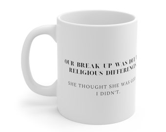 Può includere: Una tazza da caffè in ceramica bianca con testo nero che recita: "OUR BREAK UP WAS DUE TO RELIGIOUS DIFFERENCES. SHE THOUGHT SHE WAS GOD. I DIDN'T."
