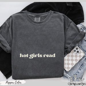 Puede incluir: Una camiseta gris oscuro con el texto "hot girls read" impreso en color amarillo claro.