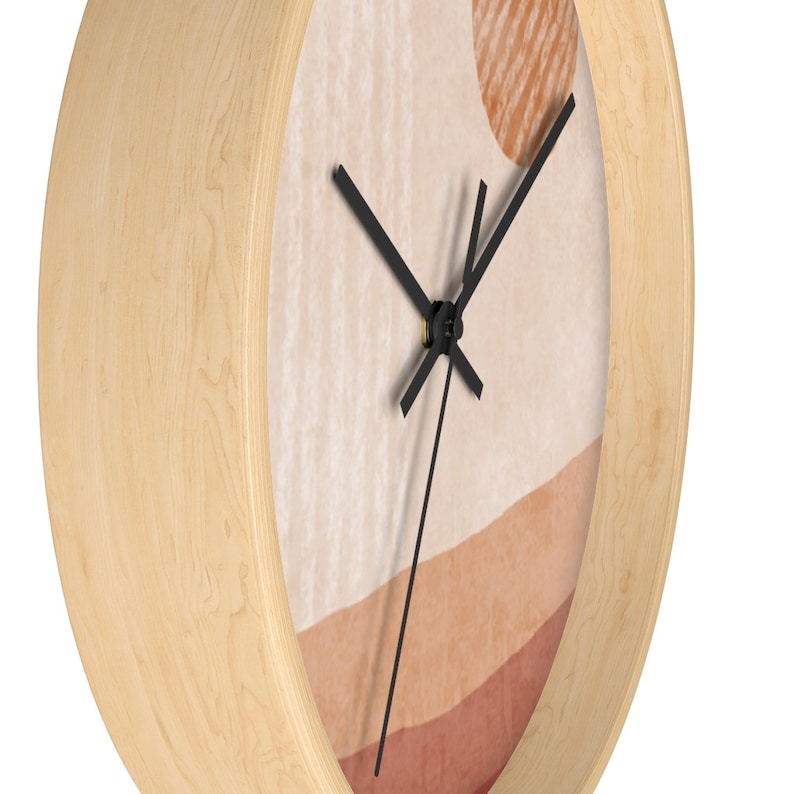 May include: A wooden wall clock with a beige, orange, and red abstract design. The clock hands are black and the clock face is round.