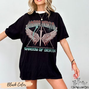 May include: Black oversized t-shirt with a graphic print of a sword with wings and the text "Shadow of Death" underneath. The text "umbra mortis" is above the sword.