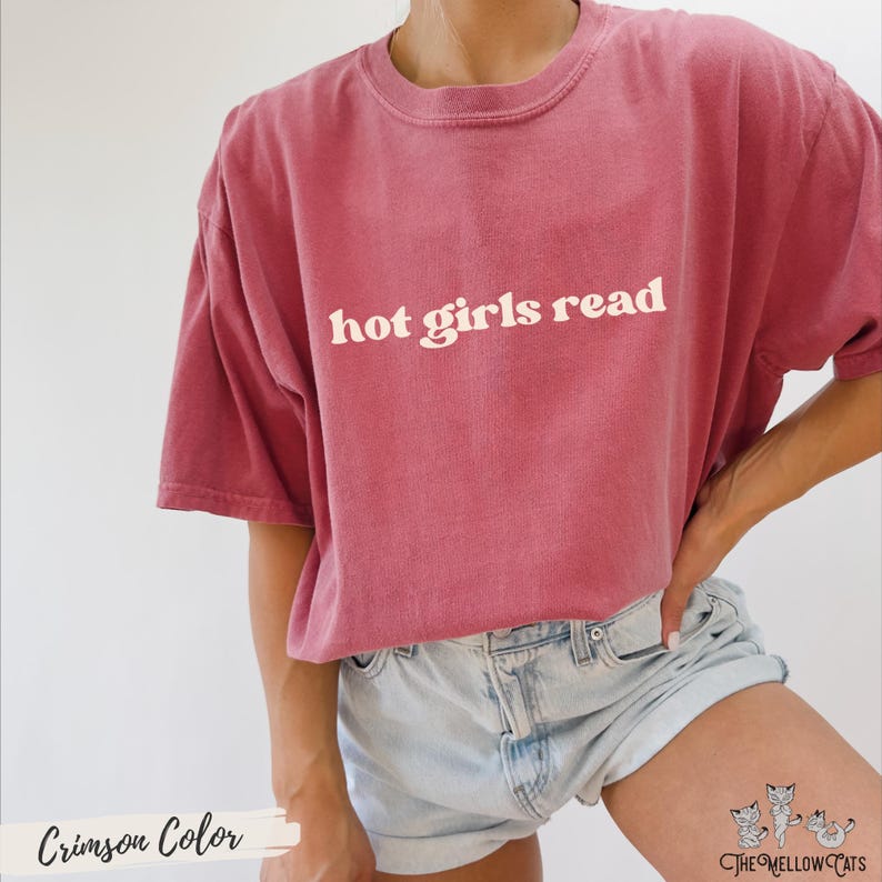 Puede incluir: Una camiseta de color carmes&iacute; con el texto "hot girls read" en blanco.