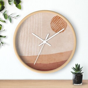 May include: A round wooden wall clock with a beige background and a brown sun design. The clock face has white hands and a minimalist design.