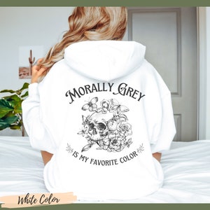 Op de afbeelding: Witte hoodie met een zwart-witte grafische print van een schedel met bloemen en vlinders. De tekst "Morally Grey is my favorite color" is op de hoodie gedrukt.