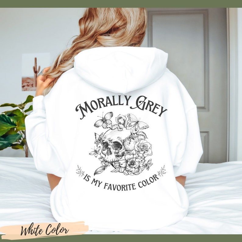 Op de afbeelding: Witte hoodie met een zwart-witte grafische print van een schedel met bloemen en vlinders. De tekst "Morally Grey is my favorite color" is op de hoodie gedrukt.