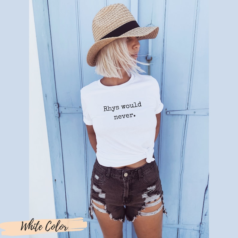 Puede incluir: Camiseta blanca con el texto "Rhys would never." impreso en negro. La modelo lleva la camiseta con un sombrero de paja y pantalones cortos de mezclilla.