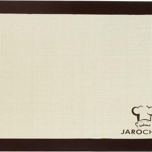 Könnte beinhalten: Eine braune Silikon-Backmatte mit einer weißen, antihaftbeschichteten Oberfläche. Die Matte hat ein kleines Kochlogo mit dem Text "JAROCHF" in der rechten unteren Ecke.