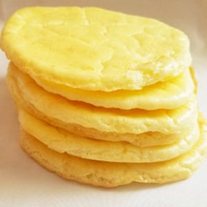 May include: A stack of five round, pale yellow, fluffy, flatbreads.