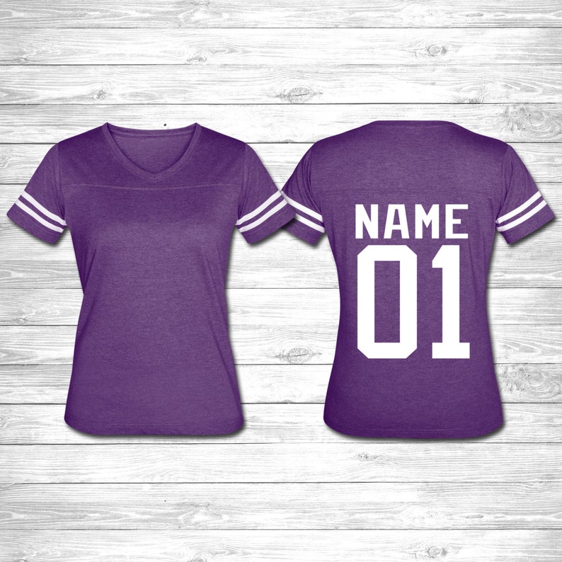 May include: Purple jersey with white stripes on the sleeves. The back of the jersey has the text "NAME 01" in white.
