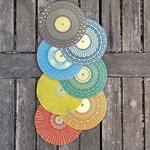 Puede incluir: Un juego de seis discos de lija con superficies abrasivas de diferentes colores. Los discos est&aacute;n apilados uno encima del otro, con el disco m&aacute;s grande en la parte inferior y el disco m&aacute;s peque&ntilde;o en la parte superior. Los discos son todos redondos y tienen un agujero en el centro para sujetarlos a una herramienta de lijado.