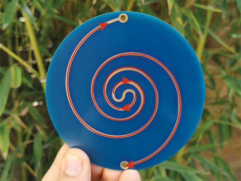 May include: A blue circular disc with a copper-colored spiral design. Red arrows indicate the direction of the spiral.