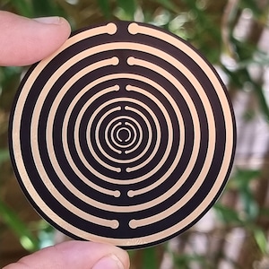 Puede incluir: Una plataforma de carga circular negra y dorada con círculos concéntricos.