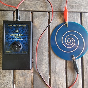 May include: A black device with the text "Zapper-Ren 7.83Hz Schumann Wave" and the words "Biofield" and "Orgone" on the front. The device is connected to a blue circular plate with a silver spiral design. The device and plate are connected by red and black wires.