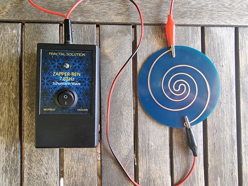 May include: A black device with the text "Zapper-Ren 7.83Hz Schumann Wave" and the words "Biofield" and "Orgone" on the front. The device is connected to a blue circular plate with a silver spiral design. The device and plate are connected by red and black wires.