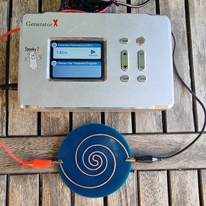 May include: A silver device labeled "Generator X" with a screen displaying "Spooky 2" and "Schumann Resonance (CAFL)" with a frequency of 7.83Hz. The device is connected to a blue circular coil with a copper spiral.