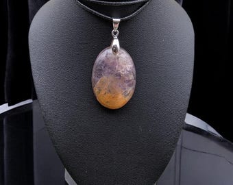 May include: A purple and orange oval-shaped gemstone pendant on a black leather cord necklace.