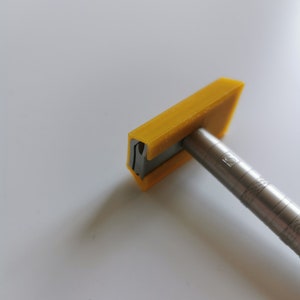 May include: A yellow plastic razor with a silver metal handle. The razor has a small hole in the top of the blade.