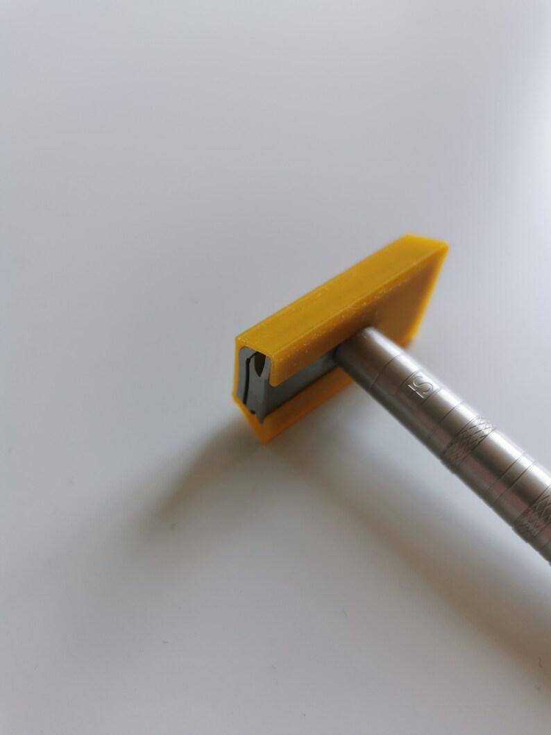 May include: A yellow plastic razor with a silver metal handle. The razor has a small hole in the top of the blade.