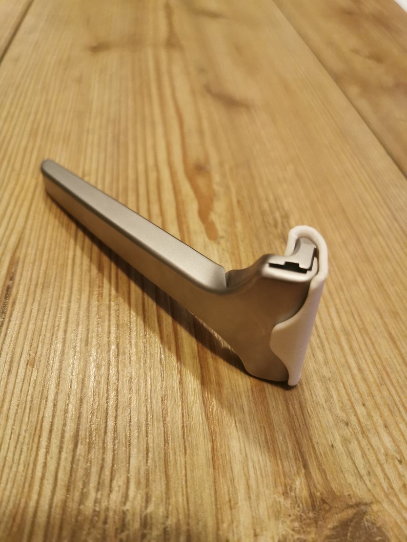 May include: A silver razor with a white plastic handle. The razor is designed for men's shaving.