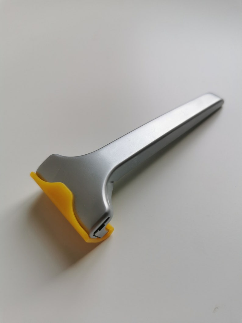 May include: A silver and yellow disposable razor with a yellow plastic handle.