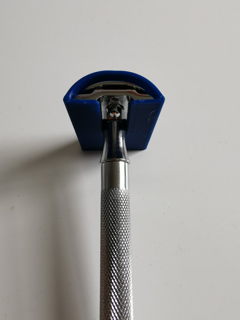 May include: A silver safety razor with a blue plastic cap. The razor has a textured handle.