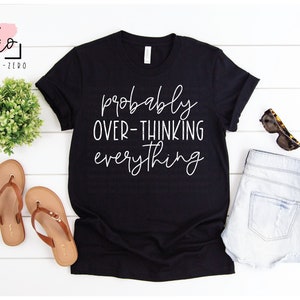 May include: Black t-shirt with white text that reads "probably over-thinking everything".