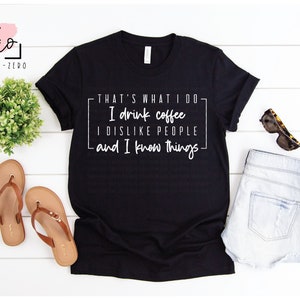 Könnte beinhalten: Schwarzes T-Shirt mit weißem Text, der "That's what I do - I drink coffee, I dislike people, and I know things." lautet.