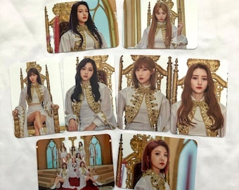 May include: Set of nine photo cards featuring a K-pop girl group in various poses. The cards are decorated with gold accents and feature the group members in elegant white outfits.