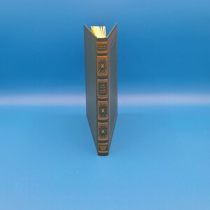 May include: A green hardcover book with gold lettering on the spine. The title is "CAPTAINS COURAGEOUS" by RUDYARD KIPLING.