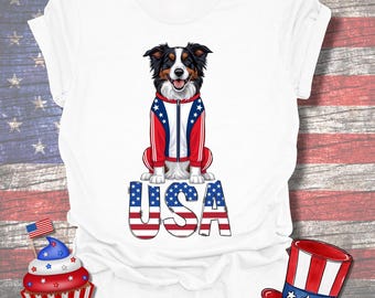 May include: White t-shirt featuring a dog wearing a red, white, and blue jacket, sitting above the word "USA" in patriotic colors. The design includes a cupcake with a flag and a red, white, and blue hat.
