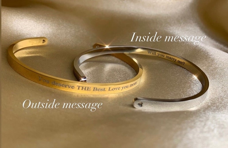 May include: Two gold bangle bracelets with engraved messages. The outside bracelet reads "You deserve THE Best. Love you most." The inside bracelet reads "Will you marry me?"